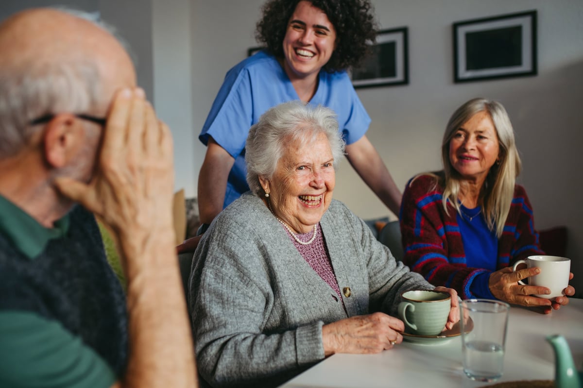 Older adults laughing together during an activity at a community center